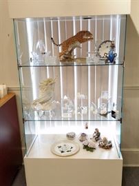 Glass display case with an assortment of cut crystal collectible fiqurines
