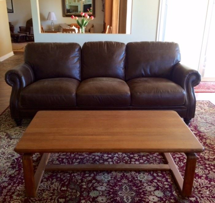 Brown leather sofa with nailhead trim and teak coffee table by Sun Cabinet.