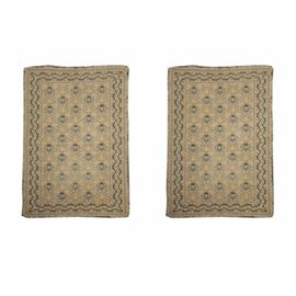 Pair of Handwoven Wool Area Rugs: A pair of matching wool rugs woven in a soumak style, or a crotchet style. The center panels feature offset rows depicting stylized pineapples in a palette of beige, light blue, dark blue and tan. The border has double rows of vine patterns, and the edges are finished all the way around with tan colored looped fringe.