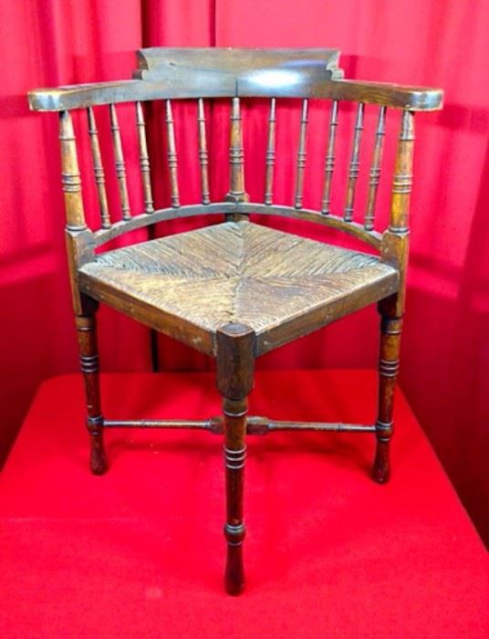 Antique corner chair with turned legs and wicker seat