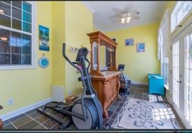The sun room showcases a beautiful oak bar with marble counter top. Very nice with extra storage behind the bar and an area above the countertop to hold glasses.