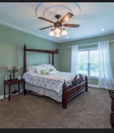 Master Room king size bed with decorative canopy. Side table and vintage ornate lamps.