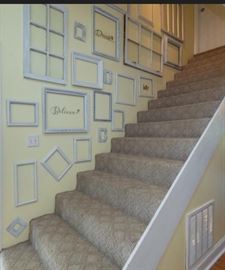 Wall of wood frames ranging in sizes and styles.
