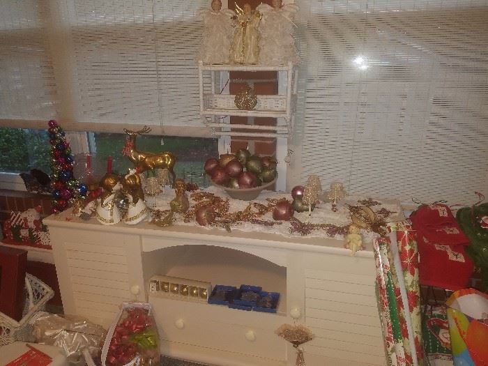 Off-white entertainment center/television stand, Christmas décor, White wicker towel rack.