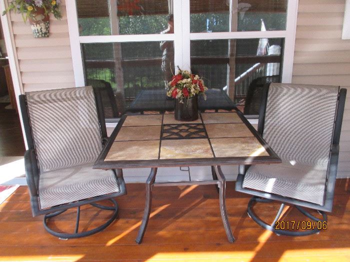 Patio set with swivel chairs.  Table top is tile squares