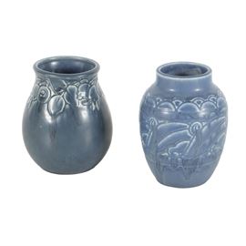Two 1920's Rookwood Pottery Vases: A collection of two ceramic vases by Rookwood Pottery, Cincinnati, Ohio. One with a matte blue glaze and tapered neck, marked to the underside with an impressed RP mark and dated “XXVI” for 1926 with the model number, 2854. A slightly darker matte blue vase with floral relief pattern around the tapered neck, marked to the underside with an impressed RP mark and dated “XXI” for 1921 with the model number, 2122.