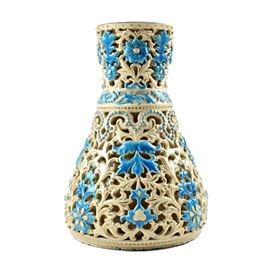 19th-Century Zsolnay Reticulated Ceramic Vase: A 19th-century Zsolnay reticulated ceramic vase, Pécs, Hungary. Ivory colored glaze with hand painted polychrome enamel and gilt decoration. Highly reticulated floral motif throughout the vase with splashes of vibrant Persian blue color in the embossed reticulation. The interior of the vase is closed off and recessed from the reticulated lobe. Marked to the underside with an impressed mark.