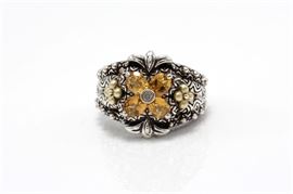 Bixby Sterling Silver 18K Gold Accented Citrine Ring: An engraved tapered sterling silver shank with round bezel set colorless topaz to the center of faceted oval cut citrine and flower shaped yellow gold accents on the sides.