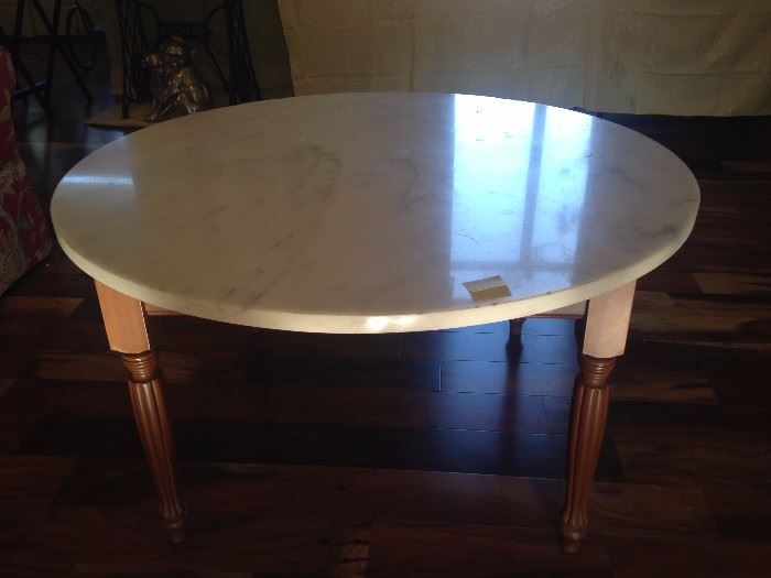 Solid marble top table with wooden legs.
