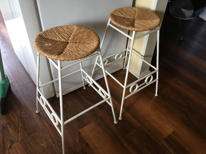 two wrought iron bar stools with rattan seats