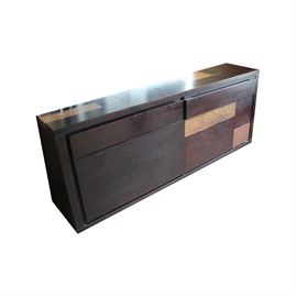 Contemporary Sideboard: A contemporary sideboard. This sideboard features a rectangular shape with a narrow top above a pair of drawers that rests above cabinet doors. The piece is constructed from wood and hammered metal pieces. This item coordinates with item: 17IND136-097.