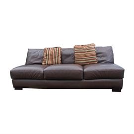 Sofa by American Leather: A sofa by American Leather. This sofa features three back cushions over three removable seat cushions that rise above a straight apron terminating on block feet. The seat is marked “American Leather.” This item matches items: 17IND136-060 and 17IND136-061.