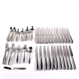 Reed and Barton "Grand Hotel" Flatware Set: A Reed and Barton flatware set. This seventy-five piece stainless steel flatware set from Reed and Barton is presented in the Grand Hotel pattern with a beaded outline to the handles. This set includes eighteen forks, twelve soup spoons, twelve teaspoons, twelve steak knives, twelve butter knives, eight spoons and one pie knife. Each is marked to the underside “Reed and Barton Stainless.”