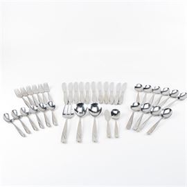 Stainless Steel Flatware Set: A stainless steel flatware set. This set features a simple curving accent design.