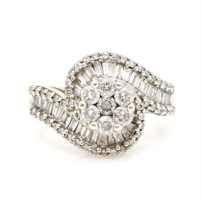 14K White Gold 1.98 CTW Diamond Ring: A 14K White Gold 1.98 ctw diamond ring. This ring features a central cluster of prong set diamonds leading to bypass style shoulders encrusted with flowing channels of diamond baguettes flanked by bead set diamond borders.
