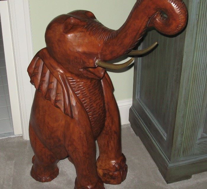 Solid wood carved elephant with brass tusks.