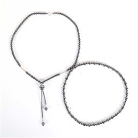 Hematite Necklace and Bracelet Set: A hematite and silvertone metal necklace and bracelet set. The necklace is beaded, strung with hematite and silver tone metal beads. The necklace is secured by spring ring clasp. The bracelet is an endless elastic strand strung with hematite beads.