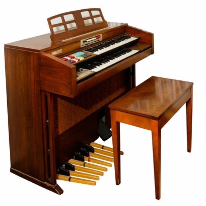 Transistor Organ with Bench by the Thomas Organ Company: A vintage transistor organ by the Thomas Organ Company. This electric solid state organ is model Californian 252 and serial number 2019179. It has a walnut veneer body and comes with a coordinating bench, along with its manual, headphones, and a selection of sheet music for the electric organ.