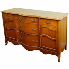 Louis XV Style Serpentine Sideboard by Paine: A Louis XV style serpentine front sideboard by Paine Furniture. It has three graduated drawers stacked in the center, flanked by a drawer over a cabinet on each side; on the right side, the drawer is divided and the cabinet is shelved. The drawers and doors have metal pulls and handles with leaf motif. It stands on flared block feet with serpentine apron. 
Matching table is item 17BOS143-176 and matching china cabinet is item 17BOS143-189.