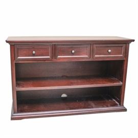 Mahogany Sideboard: A mahogany sideboard. This piece is constructed from mahogany, and it features three machine dovetailed drawers with round metal pull knobs over one height-adjustable shelf.