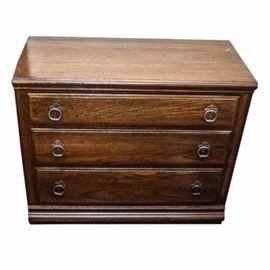 Ethan Allen Oak Small Chest: A small Ethan Allen oak chest of drawers. The three-drawer unit has Colonial styling and uses two antiqued brass-toned round pulls on each drawer. It is stained a dark brown. This item matches 17COL157-031.