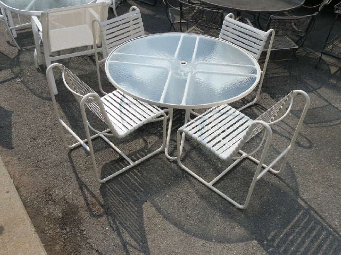 Vintage Brown Jordan dining set includes 4 chairs w/ strapping and round glass top table. Excellent original condition