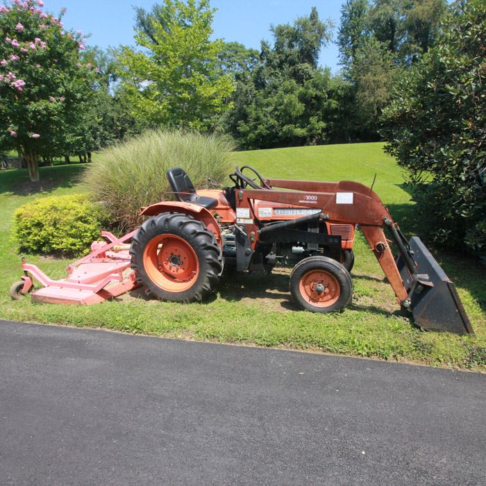 Kubota L245 Tractor: A Kubota L245 tractor with a 25 horsepower 1.1 liter 3-cylinder diesel engine, rear wheel drive and two headlights. The tractor comes with a front-end loader and a rear brush hog mowing deck. The instrument gauge reads 1900.6 hours.