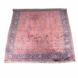 Palace Size Persian Style Silk Rug: A palace size Persian Style silk rug.This beautiful silk rug features a deep rose field with a line of central medallions surrounded by sprays of floral motifs, lotus blooms, and herati style motifs. The main indigo border along with the guard borders all show herati patterns, in colors of tans, dark brown, and red. The rug is finished with overcast edges with an applied ivory fringe to the ends. Unmarked.