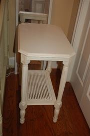 Small white rectangular table with wicker bottom shelf