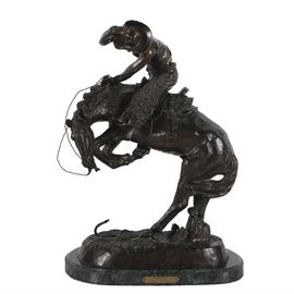 Bronze Sculpture "Rattlesnake" After the Original by Remington in 1904: A bronze sculpture titled Rattlesnake after the 1904 original by Frederick Remington. The bronze illustrates a cowboy and his bucking horse caught unaware by the rattlesnake at the horses feet, signed and copyrighted in the casting. Mounted on a green marble base with a brass title plaque.