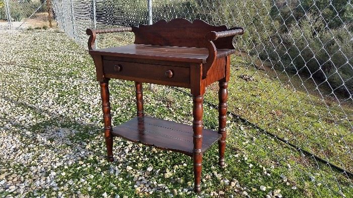 antique furniture including a washstand, glass front curio, side tables and more