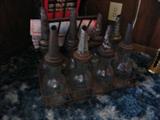 Antique gasoline bottles in carrier.