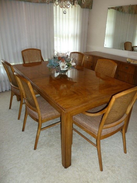Solid wood Drexel Heritage dining table.  Has six chairs with caned backs and cushion seats.