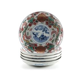 Eastern Asian Inspired Ceramic Bowls: A selection of eastern Asian inspired bowls. This selection includes five bowls featuring a central blue and white depiction of a figure at a table in a garden surrounded by a multicolored geometric, floral, and bird design around the inner rim. Each piece is unmarked.