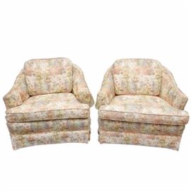 Pair of Vintage Upholstered Accent Chairs: A pair of vintage accent chairs. Each chair features a barrel back design with sloping arms, oversized cushion back and seat and box pleat skirt. The chairs are upholstered in a kaleidoscope of pastel colored flowers and are unmarked.