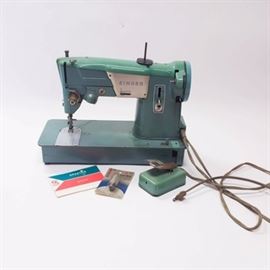 1960s Singer "Spartan" Sewing Machine: A 1960’s Singer Spartan sewing machine. This Singer Spartan sewing machine is model number 327K. Features include a green aluminum housing with zig/zag sewing, drop-in bobbin and foot pedal. This sewing machine from Singer was made in Great Britain. Includes original instruction manul and an extra light bulb.