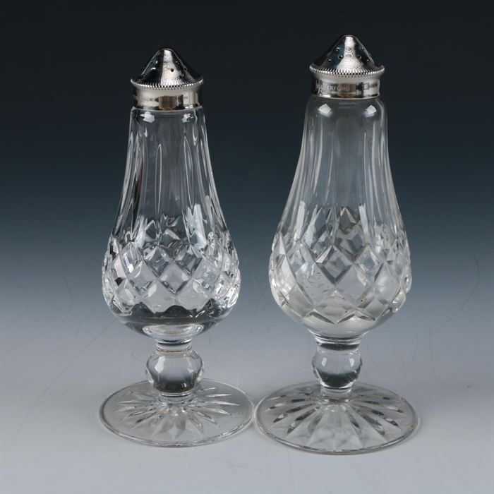 Waterford Lismore Salt and Pepper Shakers: A set of Waterford Crystal Lismore salt and pepper shakers. This pair of shakers is pear shaped, in the Lismore pattern which features cross and diamond cut designs, with silver plate lids and a star burst footed base. They are marked to the underside “Waterford.”