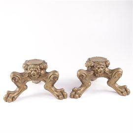 Pair of Gilt Wood Lion Paw Plant Stands: A pair of gilt wood lion paw plant stands. This matching pair of wooden plant stands features flat tops, scrolling motifs with lion head accents and curved legs on claw feet in a gold tone finish.