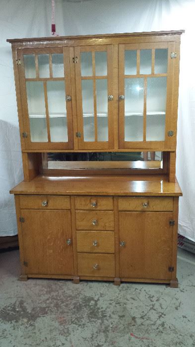 1923 Stepback Cupboard. Tigerwood Oak. Made local in Wirtz VA.  Very solid,very heavy. Has glass front cabinets on top and beveled mirror in center.  One solid piece.