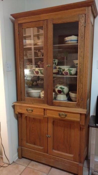 antique oak storage cabinet in laundry room