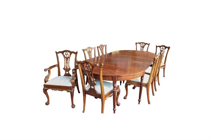 Federal Style Mahogany Dining Table: A federal style mahogany dining table, with two inserted leaves, and tapered reeded legs. This table has been paired with eight Chippendale style dining chairs, two captain style and six guest, boasting of open-work backs with ornate floral and foliate accents.
