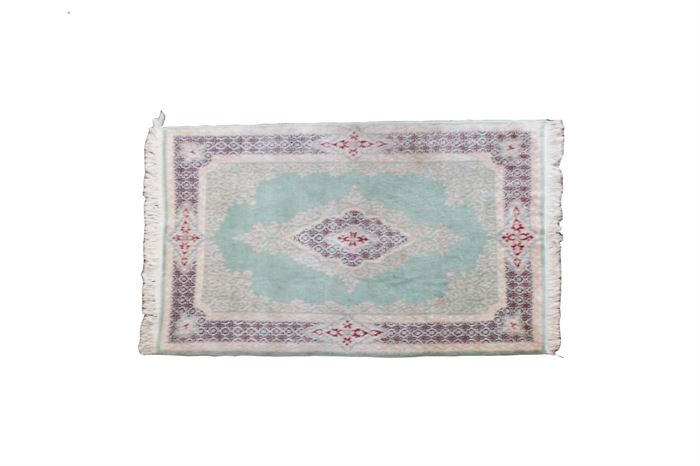Persian Style Accent Rug: A Persian style wool accent rug. This piece has an all-over floral and foliate pattern, set upon a mint green background with a central diamond shaped medallion and border with crimson, blue, cream, and beige accents. Both edges have fringe.