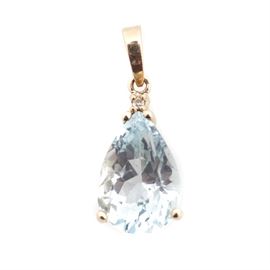 14K Yellow Gold Blue Topaz and Diamond Pendant: A 14K yellow gold blue topaz and diamond pendant. The pendant features a four prong set pear shaped blue topaz stone with a single round diamond accent.