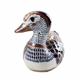 Hand Painted Stoneware Duck: A folk art inspired stoneware duck. Featured in white with hand painted detailing in shades of blue and brown, this duck is signed on the bottom with the artist’s name.