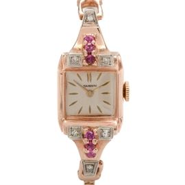 14K Rose Gold, Ruby and Diamond Tourneau Watch: A Tourneau wristwatch with rose gold case and bracelet, accented with rubies and diamonds.