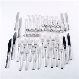 Towle "Craftsman" Sterling Silver Flatware Set: A sterling silver flatware set for eight by Towle. Produced from 1932 to 2009, this set is in the Harold E. Nock designed Craftsman pattern, which features slightly flaring handles with faceted and squared terminals. This forty piece set includes eight teaspoons, eight iced tea spoons, eight dinner forks, eight salad forks, and eight dinner knives. The forks and spoons are stamped on the reverse “Towle Sterling” next to the Towle hallmark, and the knives are marked “Towle, Sterling Handle, Stainless Blade” to the blades. The total approximate weight, excluding the dinner knives with stainless steel blades, is 38.020 ozt.