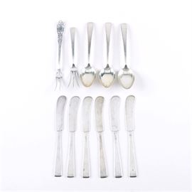 Assorted Towle Sterling Silver Flatware: An assortment of sterling silver flatware by Towle. This selection includes eleven pieces. It features six flat handle butter spreaders, one lemon fork, and three teaspoons in the Craftsman pattern. The lot also includes one lemon fork in the King Richard pattern. Each piece is stamped with the Towle maker’s mark alongside “Towle Sterling” and the total approximate weight is 9.945 ozt.