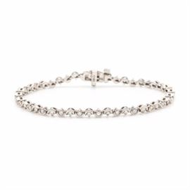 14K White Gold 1.40 CTW Diamond Bracelet: A 14K white gold 1.40 ctw diamond bracelet. This diamond tennis bracelet features half bezel set diamonds set in alternating opposing directions which create a wave effect.