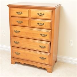 Chippendale Style Maple Chest of Drawers: A Chippendale style chest of drawers. This rectangular top chest with beveled edge and maple veneer features two top drawers with double raised panels and brass tone batwing plates and bail handles above three drawers with raised panels and batwing plates with bail handles. This piece rises on ogee bracket feet joined by a scalloped apron. For a matching piece, see item 17LEX197-013.