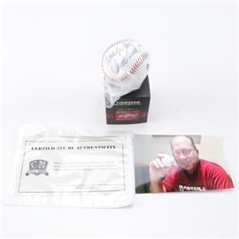 Johnny Bench Autographed Baseball: An autographed baseball. This piece is a Rawlings Official Major League Baseball and features the signature of renown baseball player Johnny Bench who is known for his tenure with the Cincinnati Reds professional baseball team. The baseball is held in a protective plastic wrapping and comes with a photograph of Bench holding a baseball as well as a COA from Classic Moments.